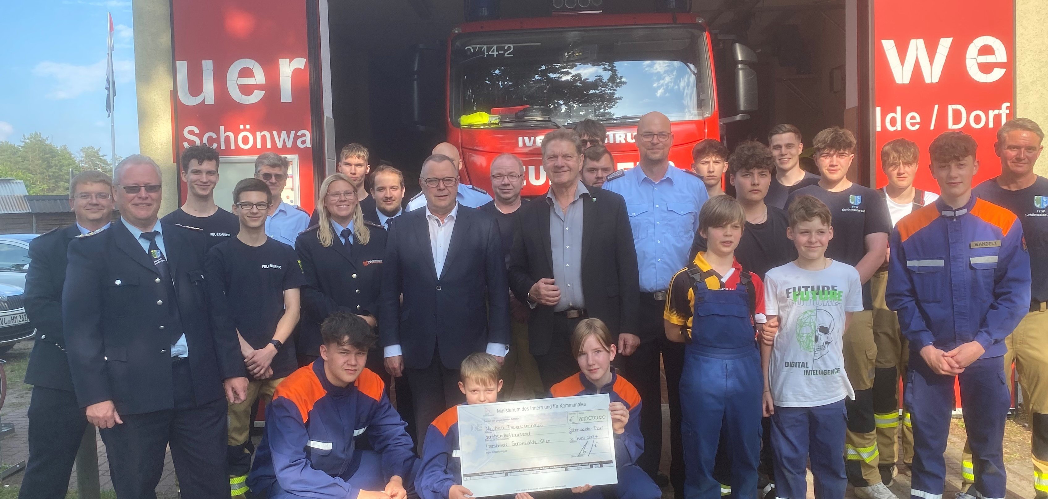 Scheckübergabe vor dem jetzigen Feuerwehrdepot im Ortsteil Schönwalde-Dorf. Innenminister Michael Stübken und Bodo Oehme zusammen mit den Kammeraden und der Jugendfeuerwehr.